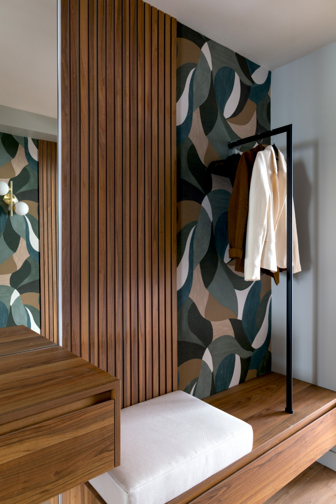 Exempel på en mellanstor modern foajé, med grå väggar, ljust trägolv, en vit dörr och brunt golv