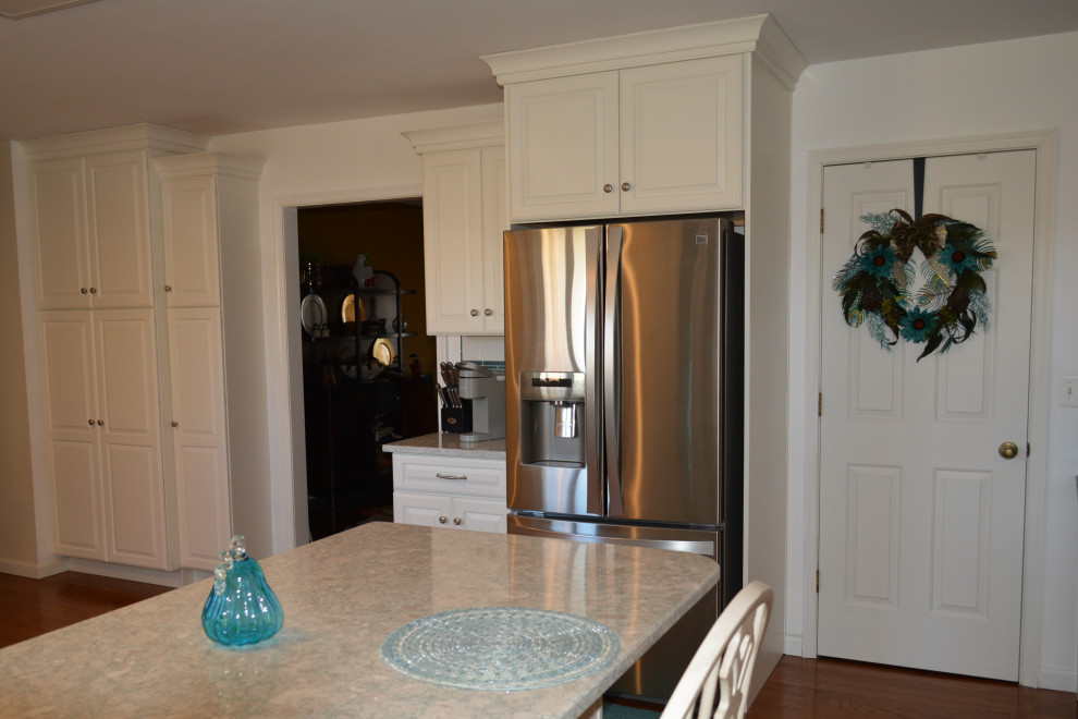 Klassisk inredning av ett stort turkos turkost kök, med en rustik diskho, luckor med upphöjd panel, vita skåp, bänkskiva i kvarts, vitt stänkskydd, stänkskydd i porslinskakel, rostfria vitvaror, mellanmörkt trägolv, en halv köksö och brunt golv