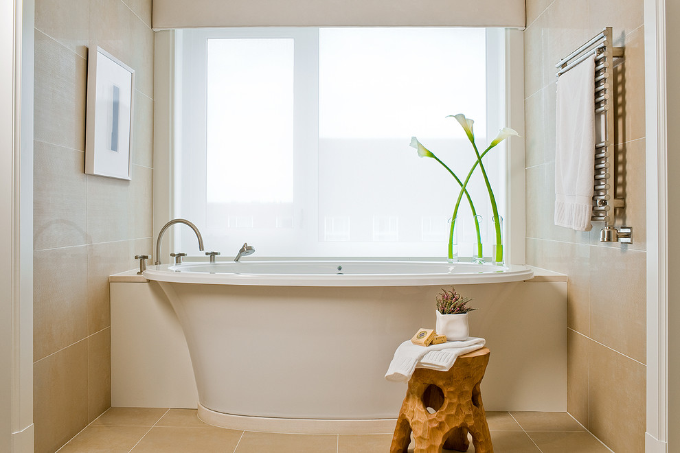 Photo of a contemporary bathroom in Boston with a freestanding tub and beige tile.