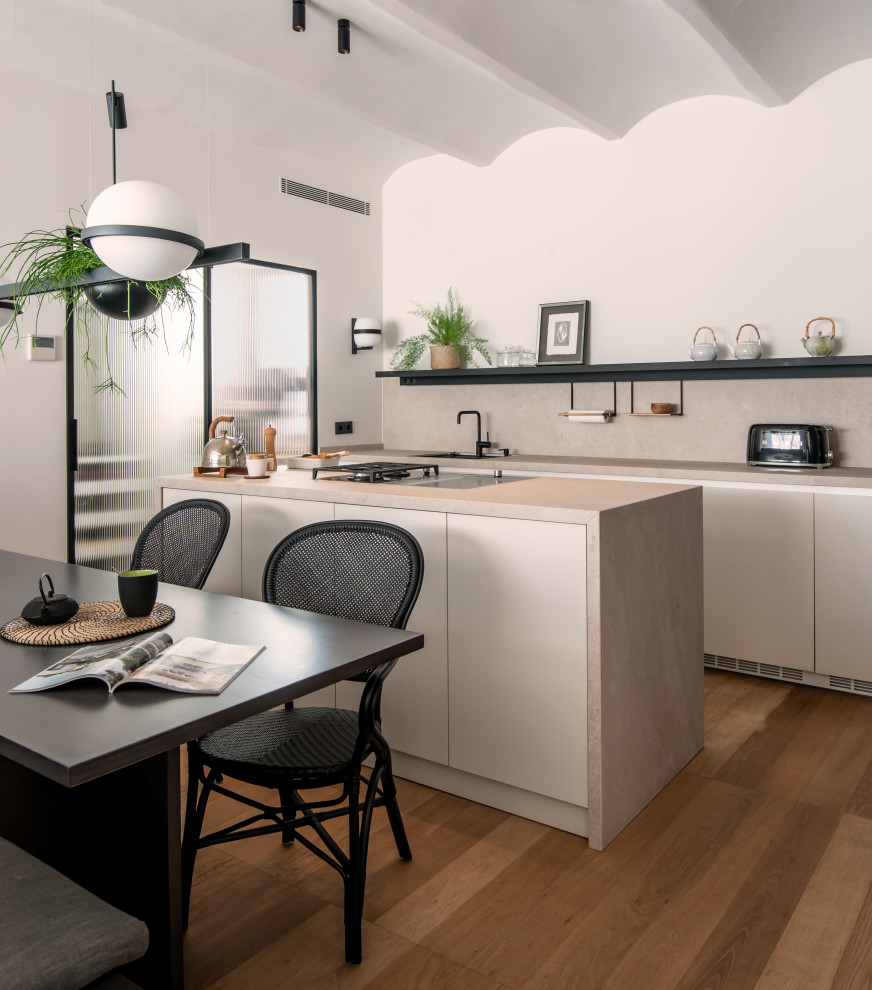 Cette image montre une cuisine ouverte linéaire et encastrable design avec un placard à porte plane, une crédence noire et îlot.