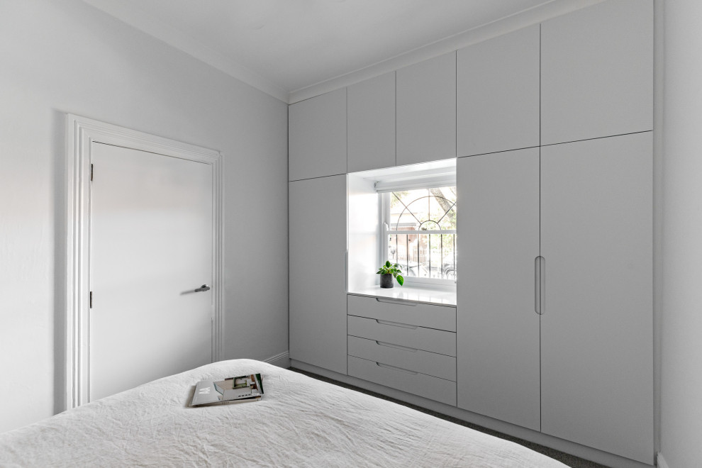 Ispirazione per una piccola camera matrimoniale design con pareti bianche, moquette e pavimento grigio