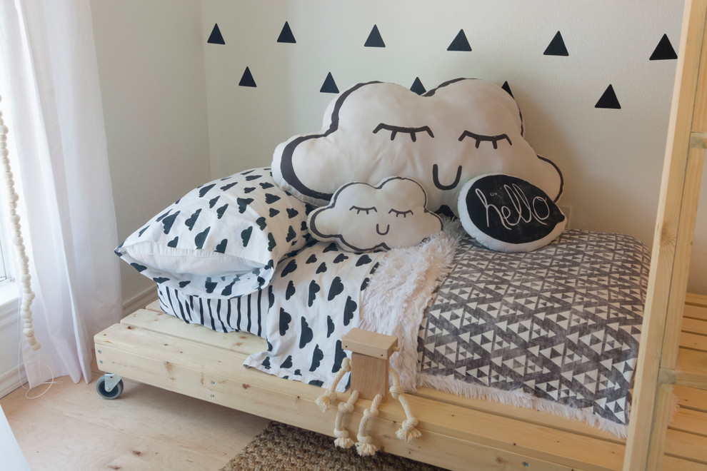 This is an example of a mid-sized modern gender-neutral kids' bedroom for kids 4-10 years old in Dallas with white walls and light hardwood floors.
