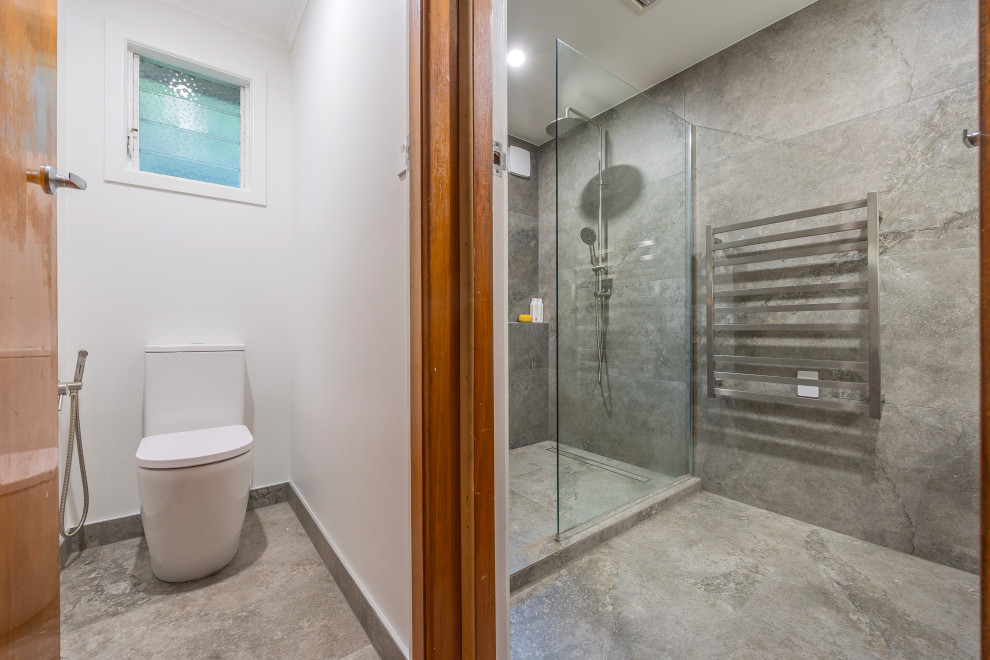 Idee per una stanza da bagno moderna di medie dimensioni con doccia aperta, bidè, piastrelle grigie, piastrelle in ceramica, pareti bianche, pavimento in cementine e pavimento grigio