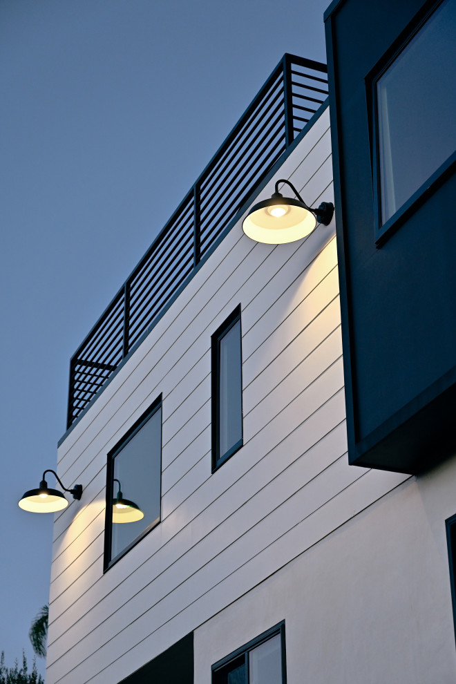 Imagen de fachada de casa blanca marinera de tamaño medio de dos plantas con revestimientos combinados, tejado plano y tejado de varios materiales