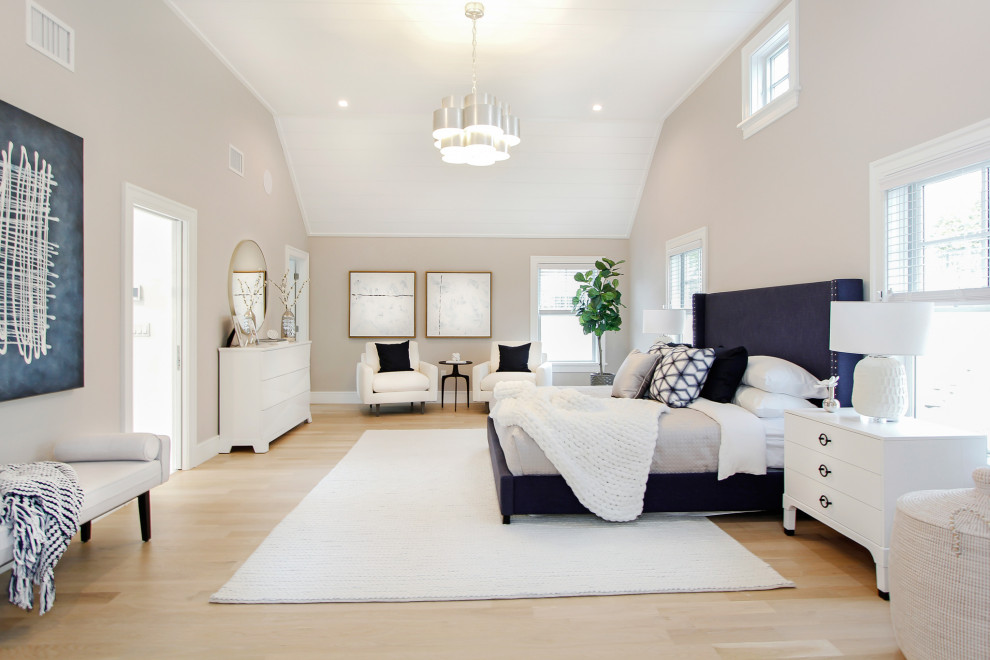 Inspiration for a large contemporary master bedroom in New York with beige walls, light hardwood flooring and a vaulted ceiling.