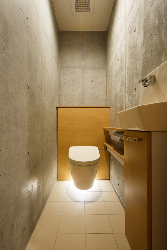 Small modern powder room in Kyoto with beige cabinets, a wall-mount toilet, beige walls, light hardwood floors, an integrated sink and brown benchtops.