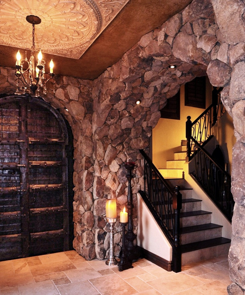 Inspiration for a mediterranean foyer with beige walls, travertine floors, a single front door and a black front door.