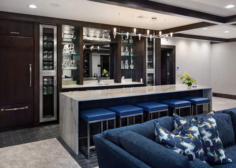 Design ideas for a large transitional seated home bar in Omaha with an undermount sink, porcelain floors, glass-front cabinets, mirror splashback, grey floor and white benchtop.