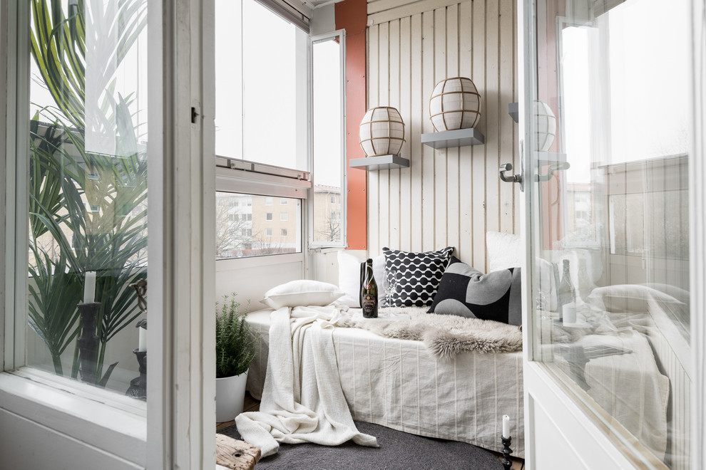 Photo of a small scandinavian balcony in Gothenburg with a roof extension and metal railing.