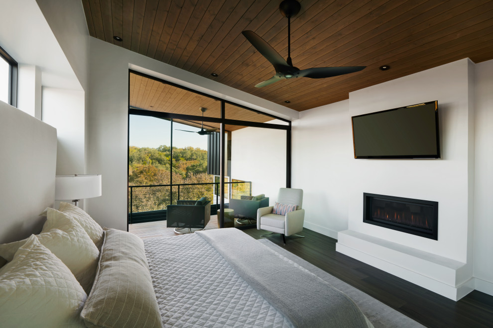 Mittelgroßes Modernes Hauptschlafzimmer mit grauer Wandfarbe, Bambusparkett, Gaskamin, verputzter Kaminumrandung, grauem Boden und Holzdecke in Austin