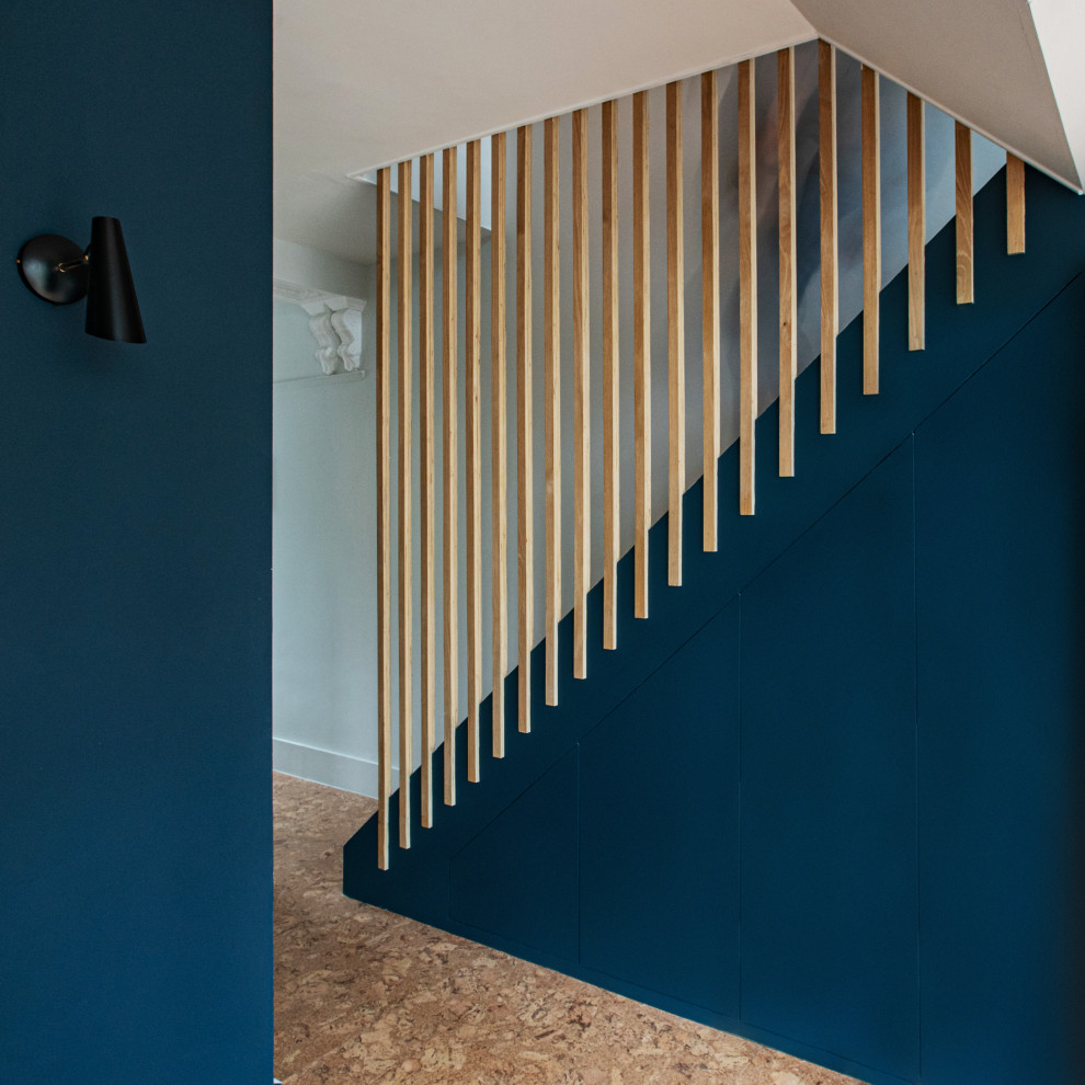Inspiration for a large contemporary wood staircase in London with wood risers and wood railing.