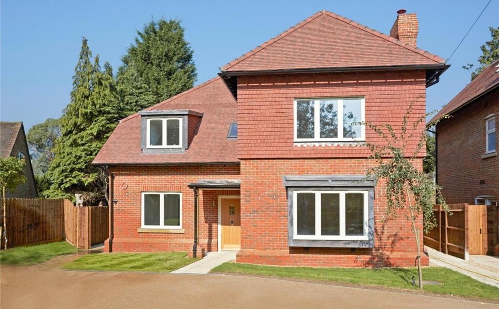 Design ideas for a large modern three-storey brick grey house exterior in Surrey with a gable roof and a tile roof.