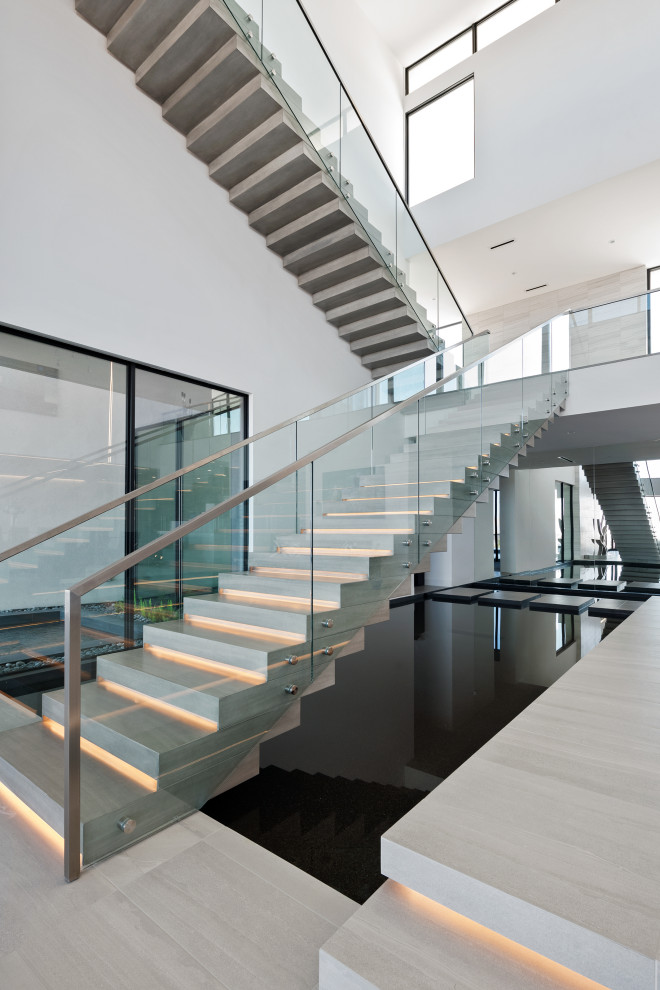 This is an example of an expansive contemporary l-shaped glass railing staircase in Las Vegas.