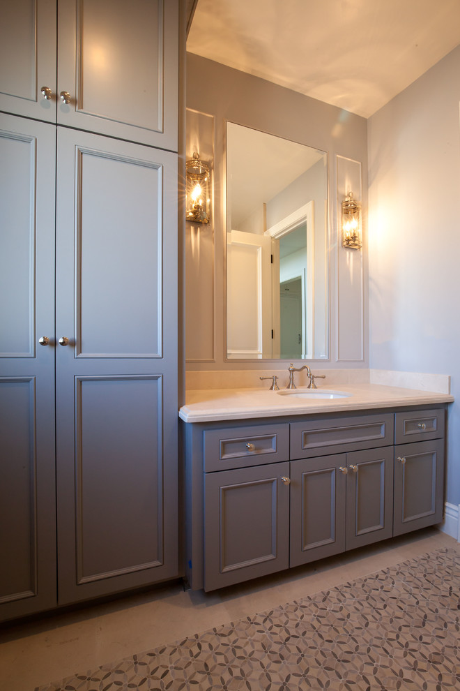 Design ideas for a mid-sized traditional 3/4 bathroom in Los Angeles with an undermount sink, recessed-panel cabinets, grey cabinets, limestone benchtops, an alcove shower, a two-piece toilet, gray tile, mosaic tile, grey walls and mosaic tile floors.