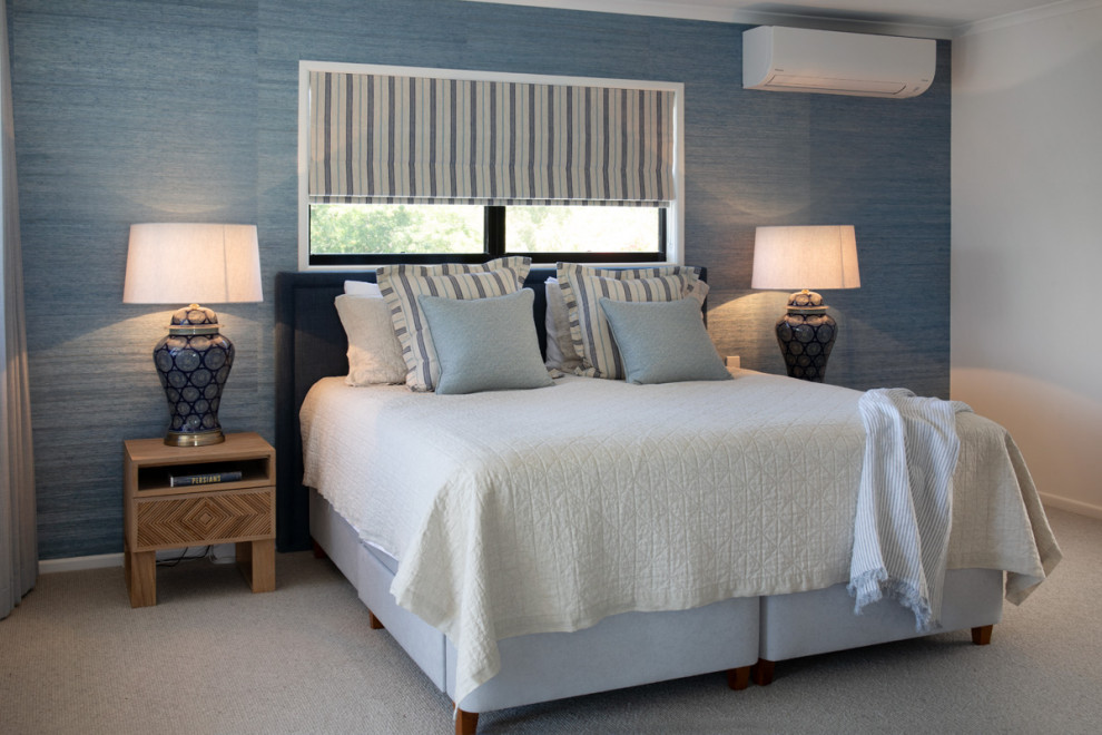 Großes Maritimes Hauptschlafzimmer mit blauer Wandfarbe, Teppichboden, beigem Boden und Tapetenwänden in Sonstige