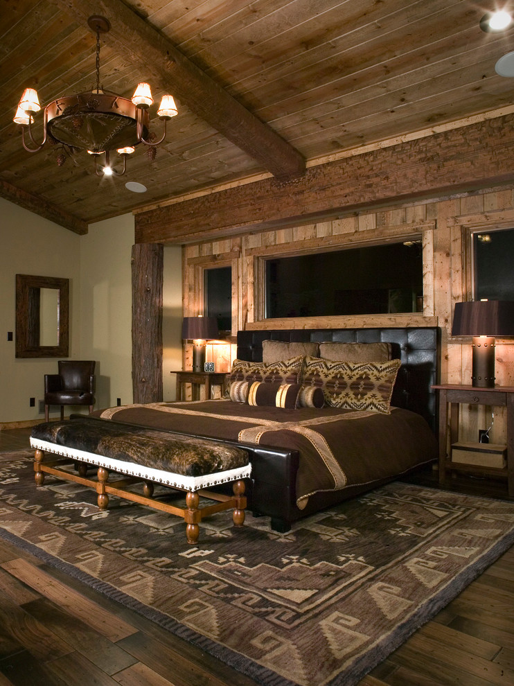 This is an example of a country bedroom in San Francisco with beige walls and dark hardwood floors.