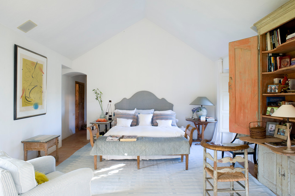 Mid-sized mediterranean master bedroom in Madrid with white walls, terra-cotta floors and no fireplace.