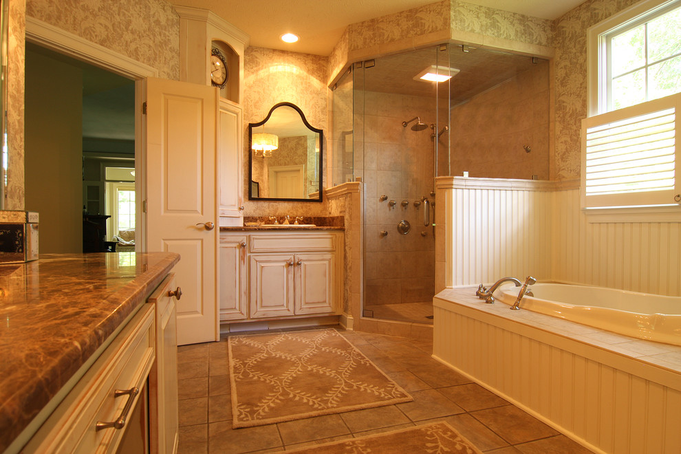 Inspiration for a mid-sized traditional bathroom in Other with a drop-in sink, raised-panel cabinets, distressed cabinets, a drop-in tub, a corner shower and beige tile.