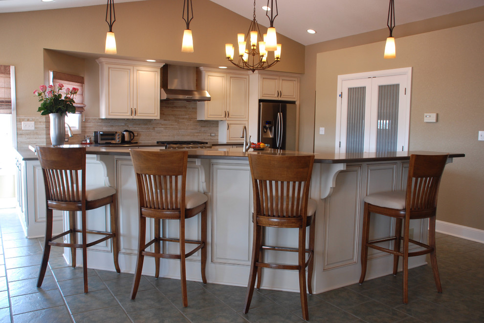 Example of a mid-sized transitional u-shaped ceramic tile open concept kitchen design in Denver with an undermount sink, raised-panel cabinets, white cabinets, quartz countertops, beige backsplash, matchstick tile backsplash, stainless steel appliances and an island