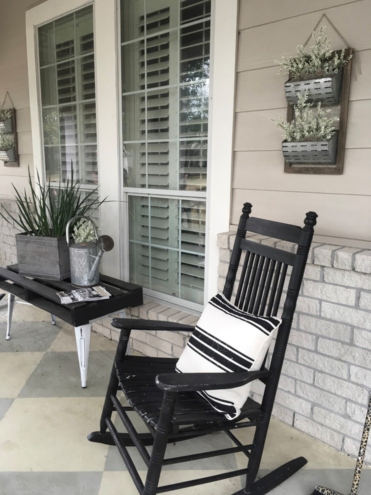 This is an example of a country front yard verandah in Houston with concrete slab.