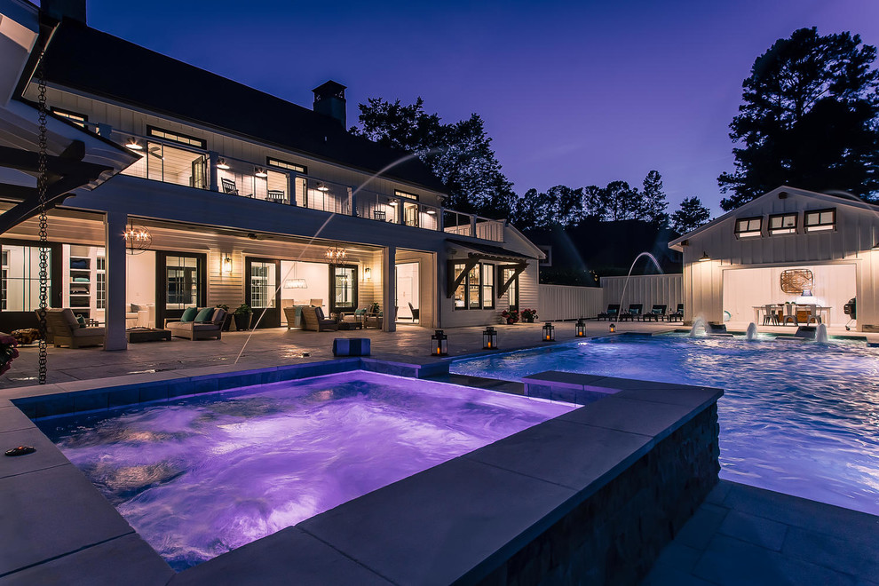 Expansive country backyard rectangular natural pool in Raleigh with a water feature and concrete pavers.