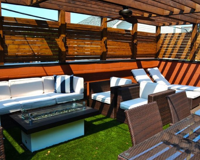 Photo of a small modern rooftop deck in Chicago with a fire feature and a pergola.