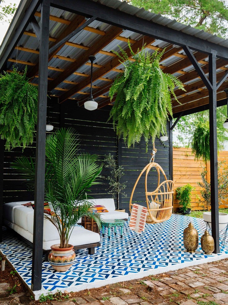 This is an example of an eclectic patio in New Orleans with tile and a gazebo/cabana.