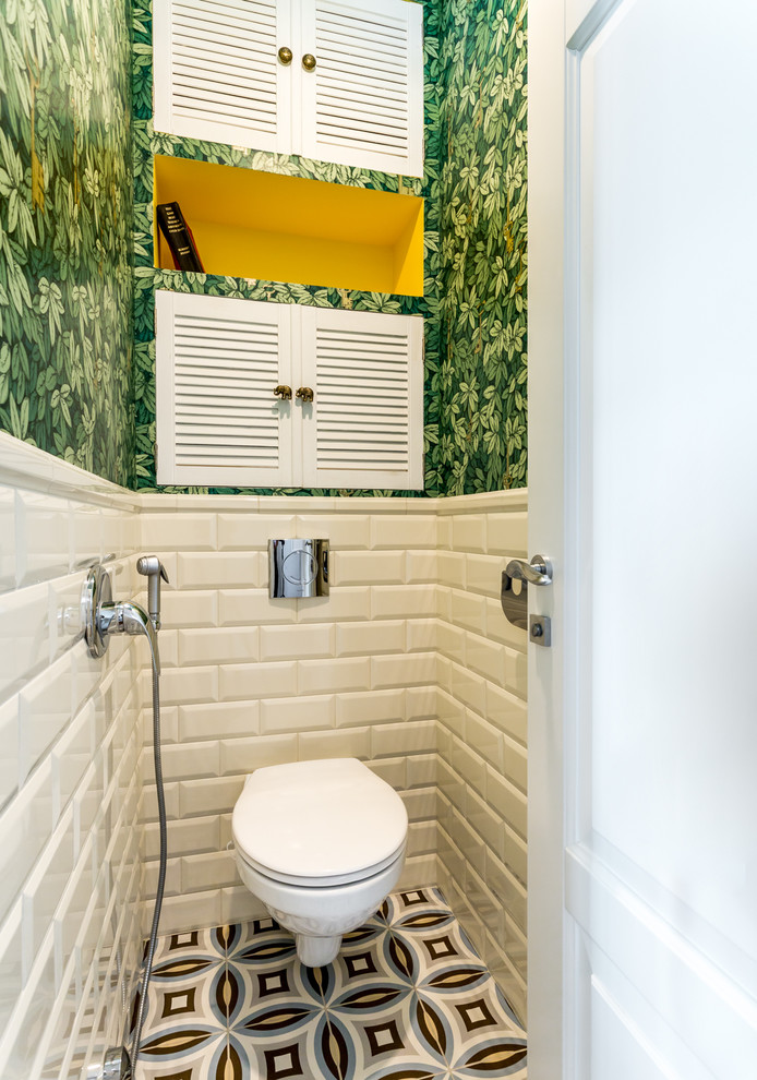 This is an example of a small eclectic powder room in Moscow with a wall-mount toilet, white tile, subway tile, green walls and multi-coloured floor.