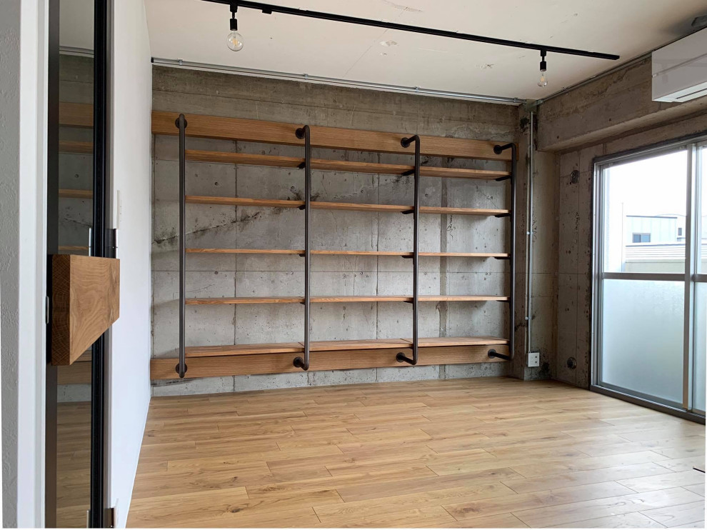 Design ideas for a mid-sized industrial open concept living room in Tokyo with a library, grey walls, medium hardwood floors, no fireplace, yellow floor, timber and planked wall panelling.