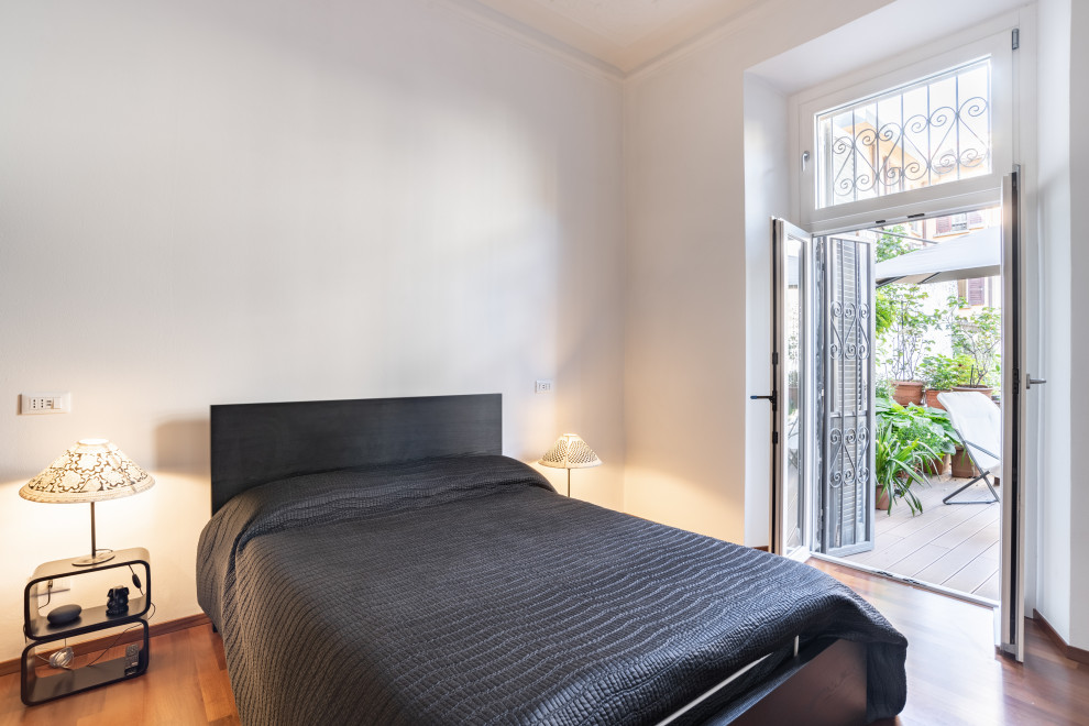 Immagine di una camera matrimoniale minimal di medie dimensioni con pareti bianche, parquet scuro e pavimento marrone