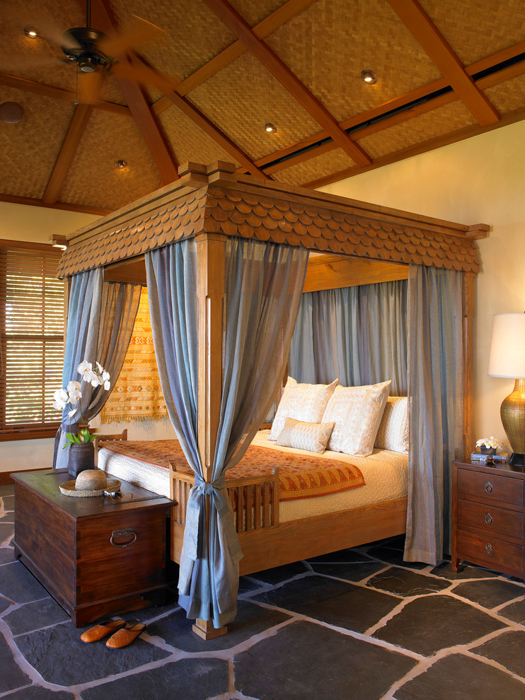 Inspiration for a tropical bedroom in San Francisco with beige walls and slate floors.