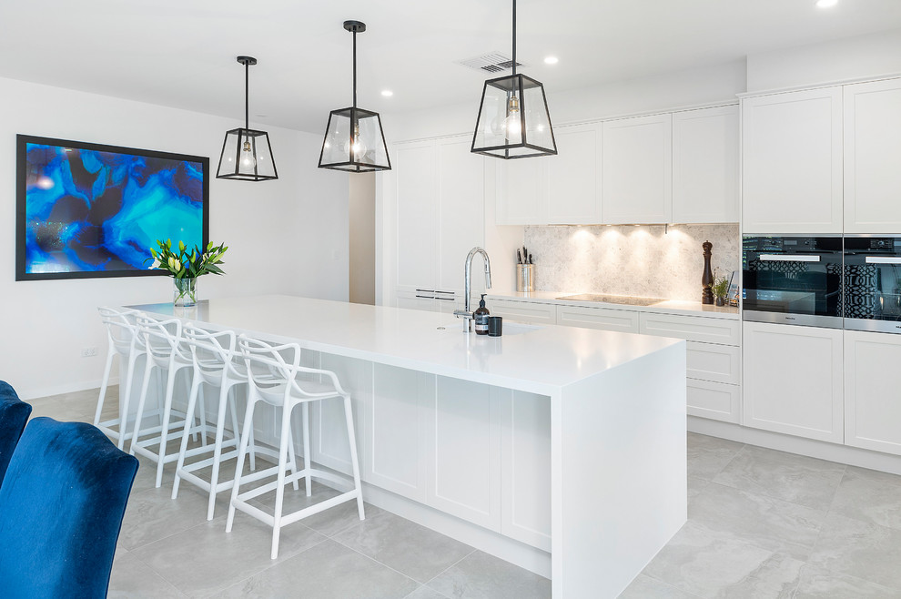 This is an example of a contemporary galley kitchen in Other with shaker cabinets, white cabinets, with island, grey floor and white benchtop.