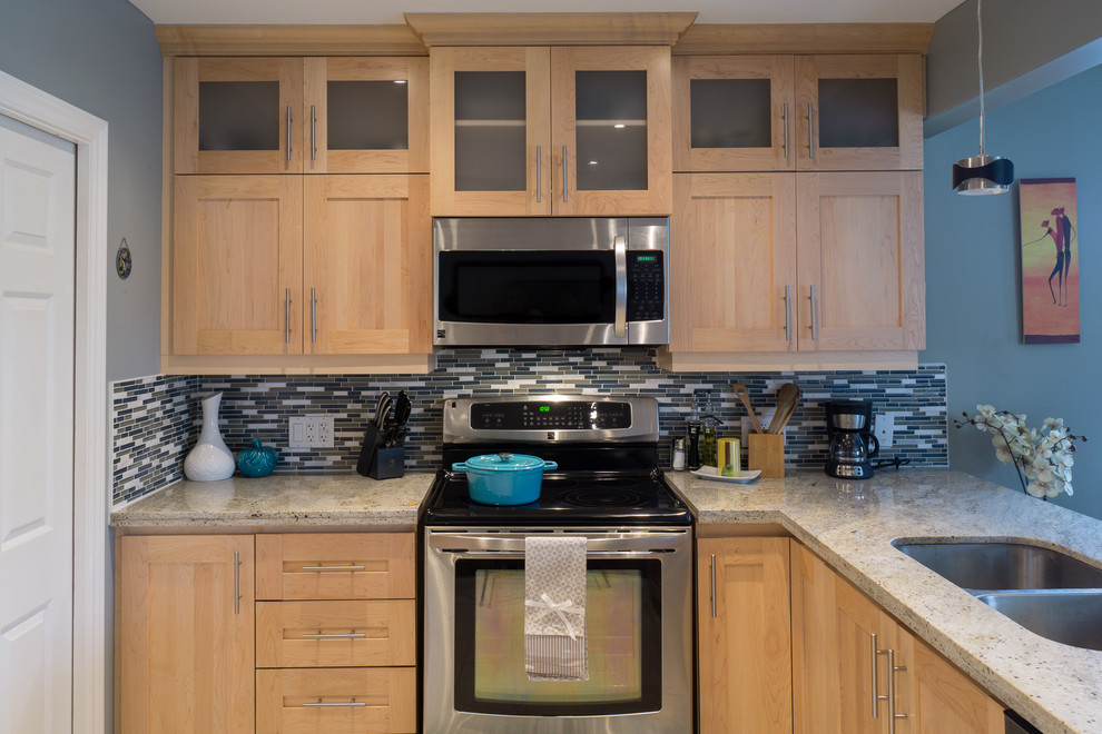 Example of a small transitional l-shaped porcelain tile eat-in kitchen design with a double-bowl sink, shaker cabinets, light wood cabinets, granite countertops, blue backsplash, glass tile backsplash, stainless steel appliances and a peninsula