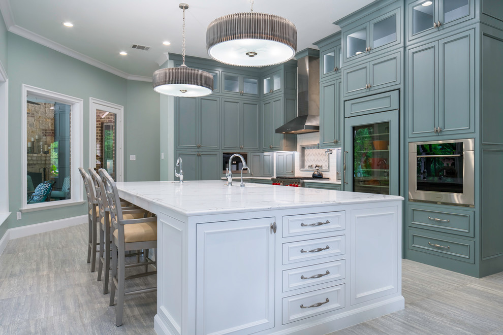 Inspiration for a large transitional u-shaped open plan kitchen in Dallas with an undermount sink, raised-panel cabinets, white cabinets, marble benchtops, white splashback, ceramic splashback, panelled appliances, porcelain floors and with island.