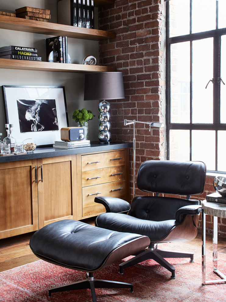 This is an example of an industrial home office in San Francisco with brown walls, medium hardwood floors and brown floor.