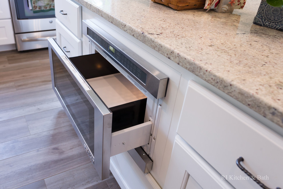 Example of a large transitional l-shaped porcelain tile eat-in kitchen design in Providence with an undermount sink, recessed-panel cabinets, white cabinets, granite countertops, gray backsplash, ceramic backsplash, stainless steel appliances, green walls and an island