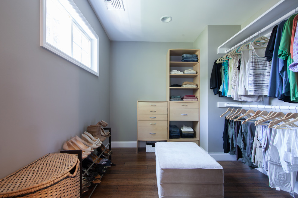 This is an example of a traditional gender-neutral walk-in wardrobe in New York with bamboo floors.