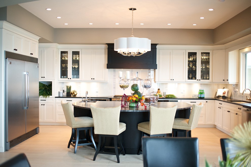 Example of a large transitional u-shaped light wood floor eat-in kitchen design in Edmonton with shaker cabinets, white cabinets, granite countertops, white backsplash, stone tile backsplash, stainless steel appliances and an island