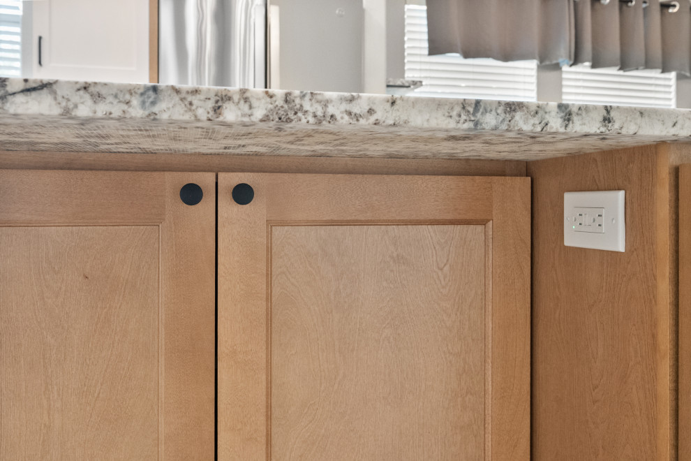 Example of a white floor kitchen design in Dallas with medium tone wood cabinets, stainless steel appliances, an island and white countertops
