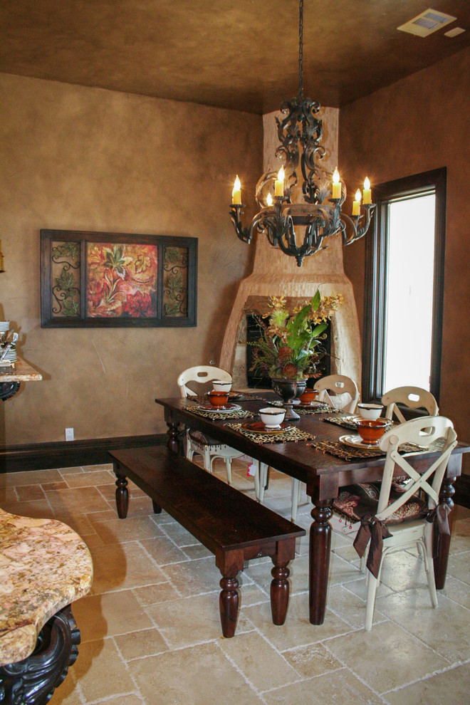Photo of a mid-sized mediterranean kitchen/dining combo in Austin with beige walls, ceramic floors, a corner fireplace, a brick fireplace surround and beige floor.