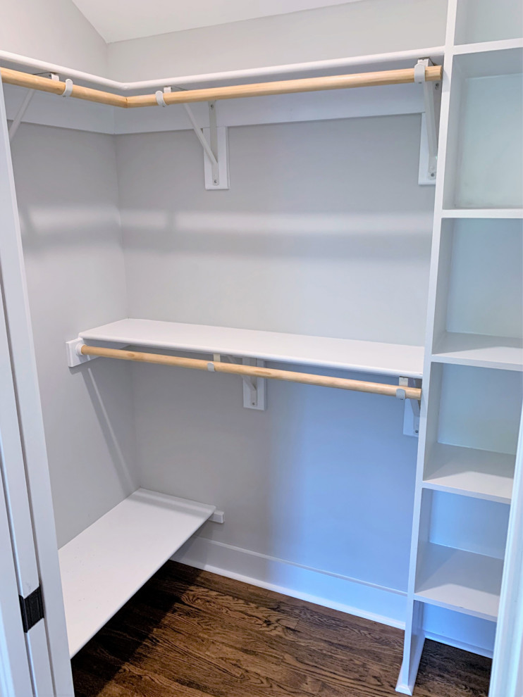 Photo of a mid-sized traditional gender-neutral walk-in wardrobe in Richmond with medium hardwood floors and brown floor.