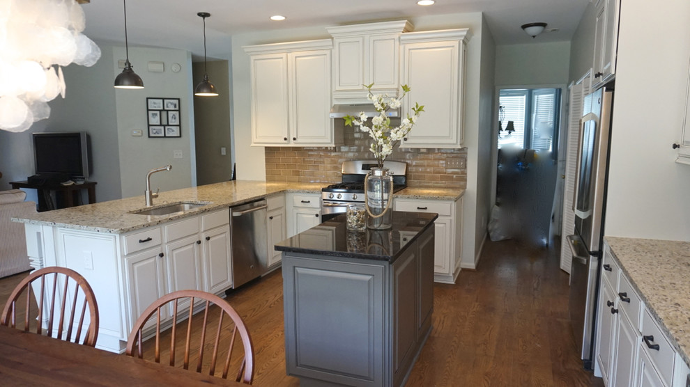 Example of a large transitional u-shaped medium tone wood floor eat-in kitchen design in Atlanta with an undermount sink, raised-panel cabinets, white cabinets, granite countertops, gray backsplash, ceramic backsplash, stainless steel appliances and an island