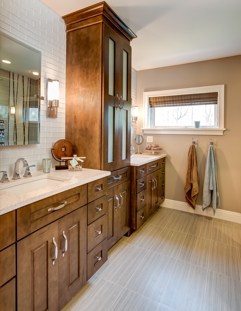 Mid-sized transitional master bathroom in Cleveland with recessed-panel cabinets, brown cabinets, a curbless shower, a one-piece toilet, gray tile, porcelain tile, grey walls, porcelain floors, an undermount sink, engineered quartz benchtops and beige floor.