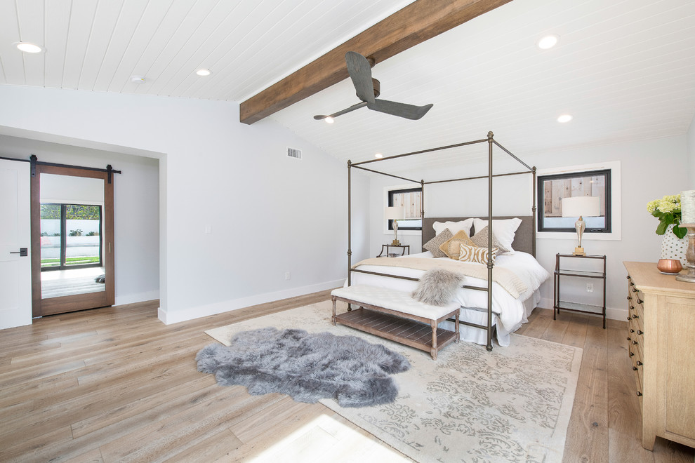 Photo of a transitional bedroom in Orange County with white walls, light hardwood floors and beige floor.