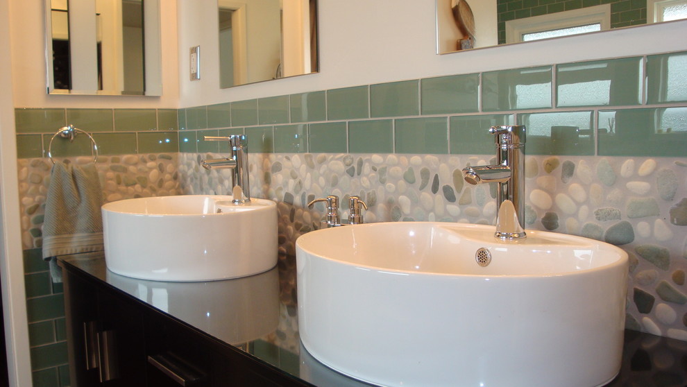 ハワイにあるお手頃価格のコンテンポラリースタイルのおしゃれな浴室 (ベッセル式洗面器、家具調キャビネット、濃色木目調キャビネット、ガラスの洗面台、緑のタイル、サブウェイタイル) の写真
