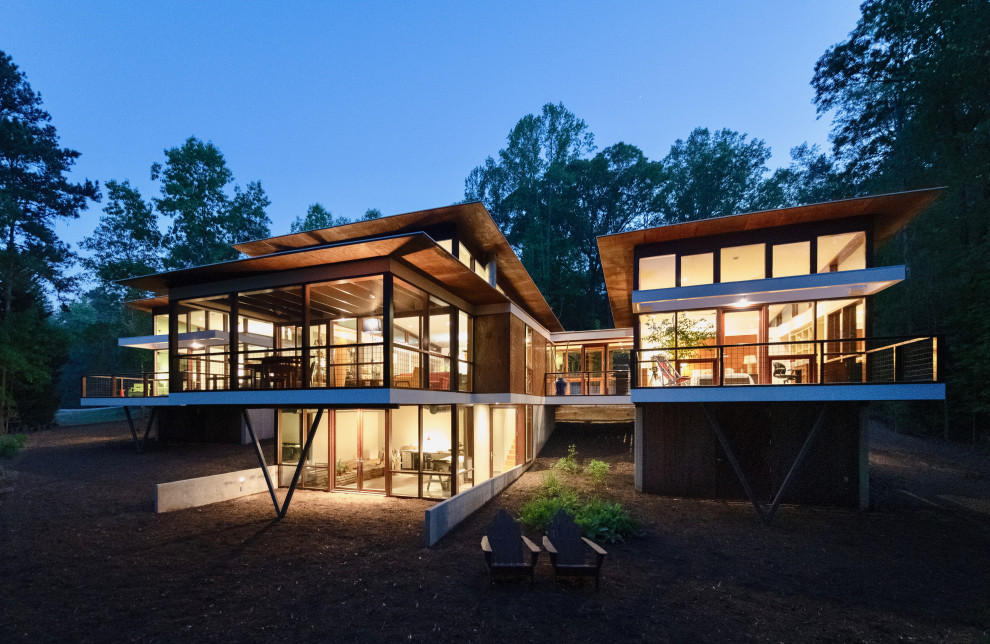 Photo of a mid-sized modern one-storey house exterior in Atlanta with metal siding, a butterfly roof and a white roof.