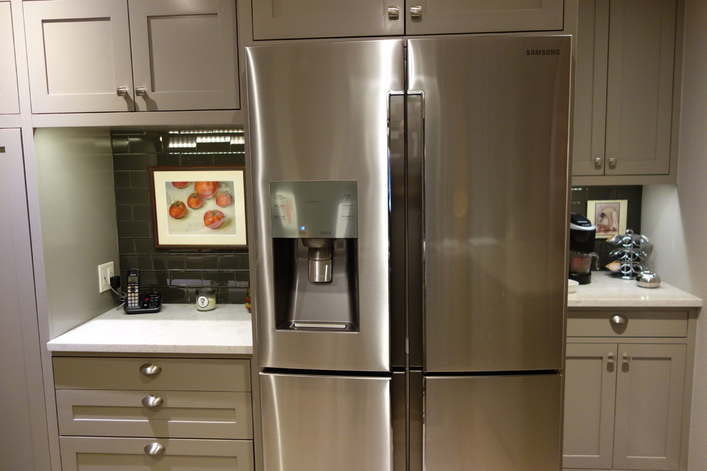 Inspiration for a small transitional u-shaped ceramic tile home design remodel with an undermount sink, shaker cabinets, gray cabinets, quartz countertops, gray backsplash, glass tile backsplash, stainless steel appliances and a peninsula