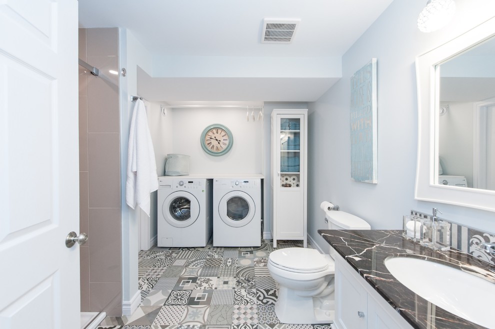 Photo of a contemporary 3/4 bathroom in Ottawa with recessed-panel cabinets, white cabinets, an alcove shower, a two-piece toilet, brown tile, white walls, cement tiles, an undermount sink, multi-coloured floor and a shower curtain.