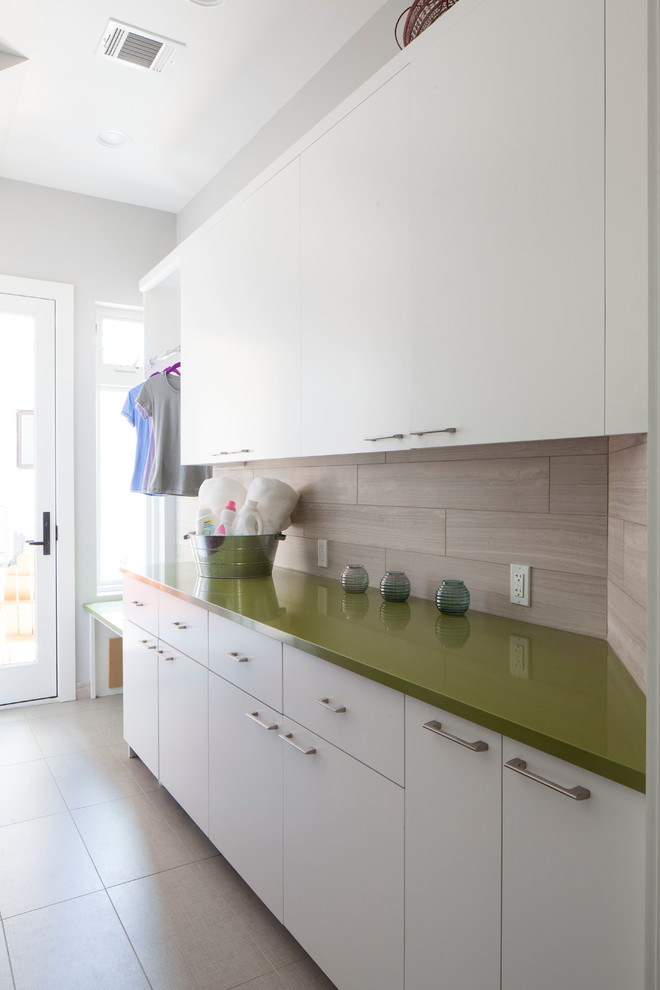 Photo of a contemporary laundry room in Austin with white cabinets and green benchtop.