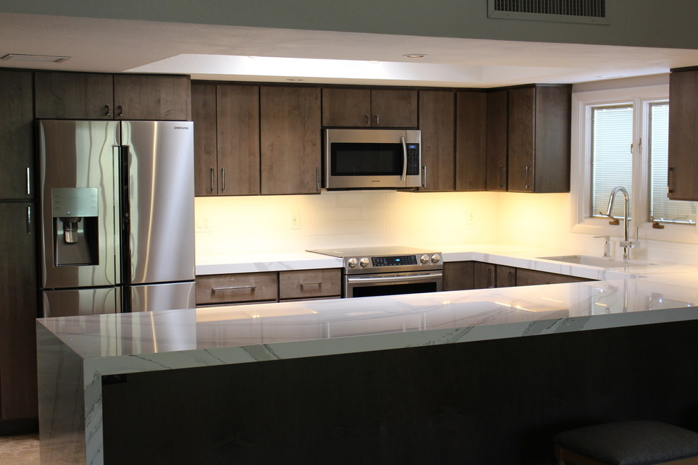 Example of a mid-sized transitional u-shaped ceramic tile open concept kitchen design in Phoenix with an undermount sink, flat-panel cabinets, gray cabinets, quartz countertops, white backsplash, porcelain backsplash, stainless steel appliances and a peninsula